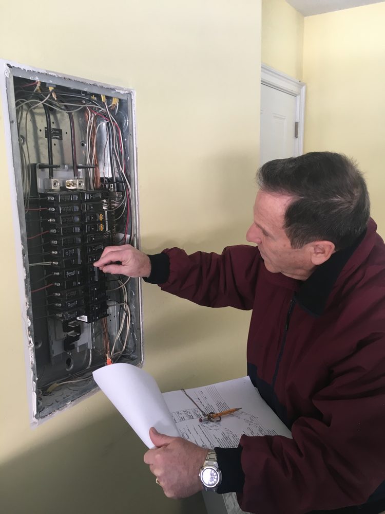 Total Home Inspection examining a circuit breaker in a client's home. Total Home Inspection examining a circuit breaker in a client's home.